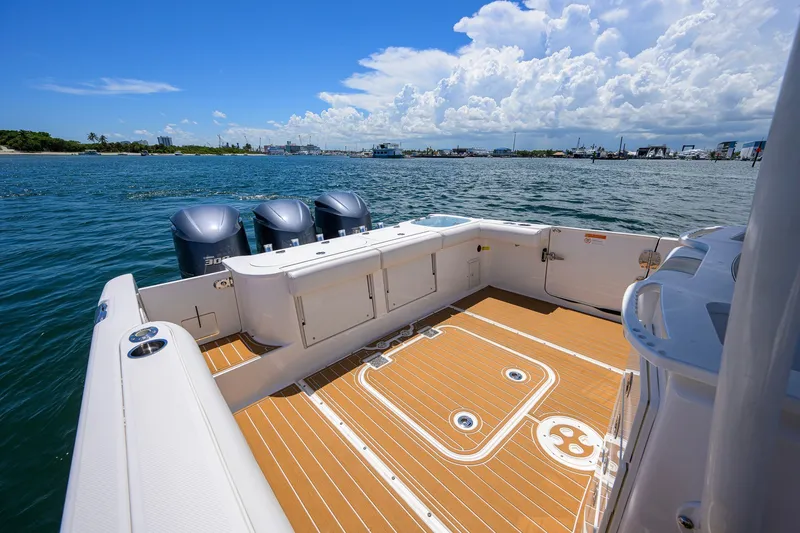 Slide: The Image of 2018 Everglades 355 Center Console boat on water, featuring spacious deck and triple engines. - 30