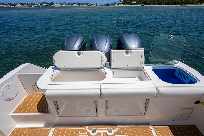 Slide: The Image of 2018 Everglades 355 Center Console boat with triple engines and open storage compartments. - 48