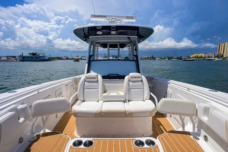 Slide: The Image of 2018 Everglades 355 Center Console boat with white seating, docked on a sunny day. - 28