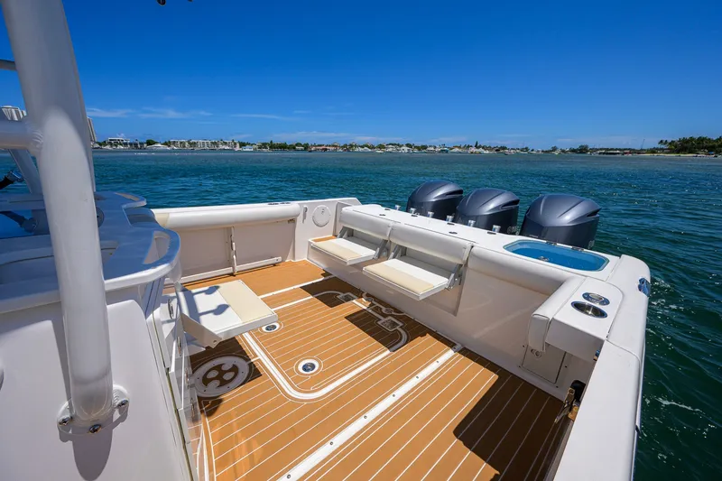 Slide: The Image of 2018 Everglades 355 Center Console boat on water, featuring spacious deck and triple engines. - 34