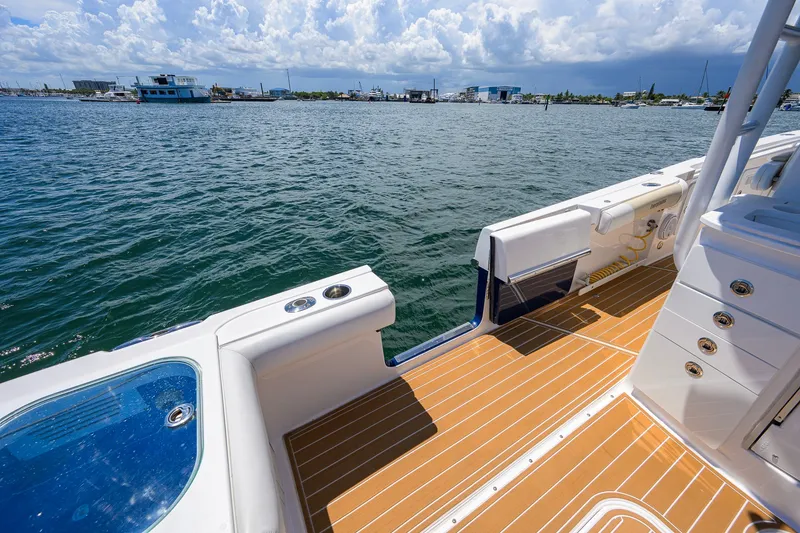 Slide: The Image of 2018 Everglades 355 Center Console boat with teak deck, docked on a sunny day. - 42