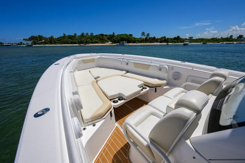 Slide: The Image of 2018 Everglades 355 Center Console boat with luxurious seating, cruising near a tropical island. - 24