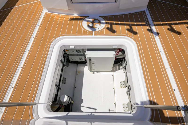 Slide: The Image of Open hatch on 2018 Everglades 355 Center Console boat deck, revealing storage compartment. - 46