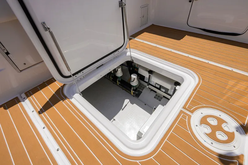 Slide: The Image of Open hatch on 2018 Everglades 355 Center Console boat deck, revealing storage compartment. - 45