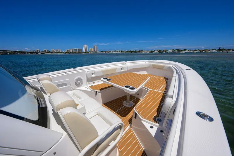 Slide: The Image of 2018 Everglades 355 Center Console boat with seating and table on calm water. - 15