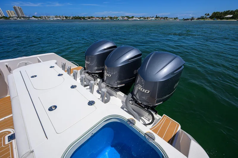 Slide: The Image of 2018 Everglades 355 Center Console boat with triple outboard engines on open water. - 59
