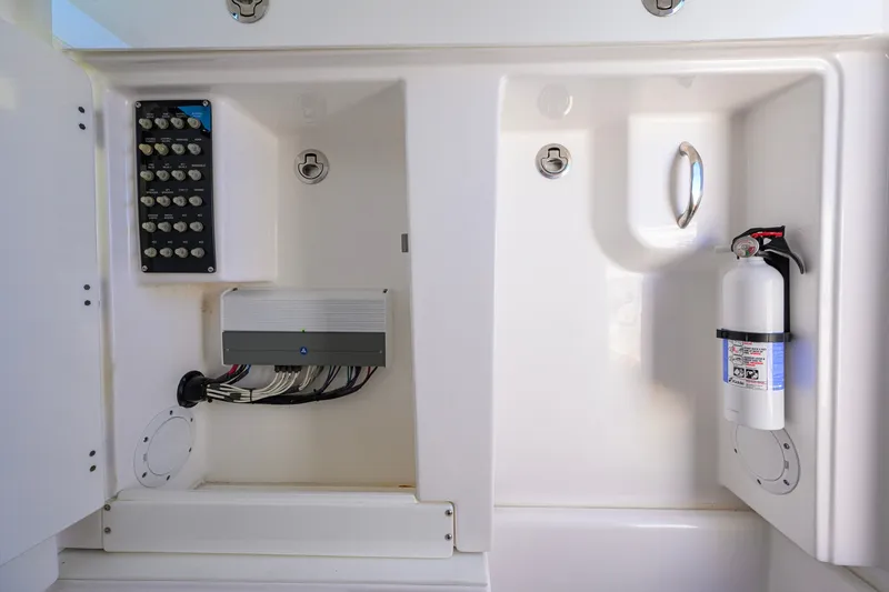 Slide: The Image of Electrical panel and fire extinguisher inside 2018 Everglades 355 Center Console boat compartment. - 55