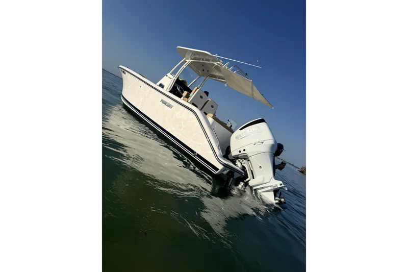 Slide: The Image of 2017 Pursuit C 238 Center Console boat on calm water, clear sky background. - 1