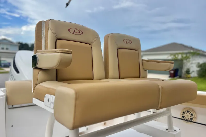 Slide: The Image of 2017 Pursuit C 238 Center Console boat seat with tan upholstery and armrests. - 29