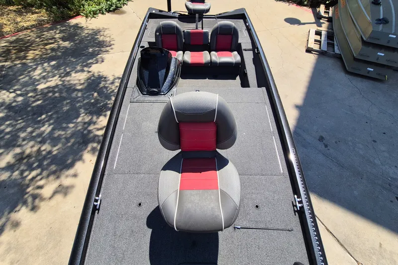 Slide: The Image of 2019 Ranger RT188 boat interior with gray and red seating, docked outdoors. - 13
