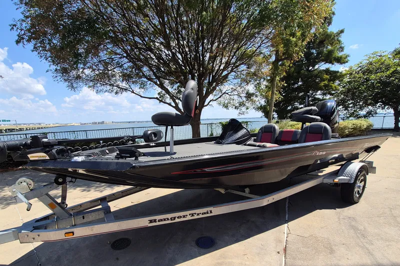 Slide: The Image of 2019 Ranger RT188 boat on trailer by lakeside, under a tree, sunny day. - 1