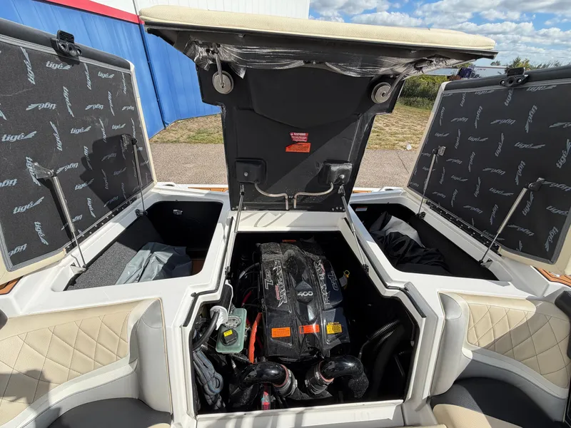 Slide: The Image of Engine compartment of a 2019 Tigé 20RZX with open hatches, showing the engine and storage space. - 8