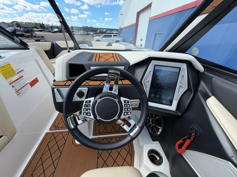 Slide: The Image of The image shows the cockpit of a 2019 Tigé 20RZX boat with a modern steering wheel and touchscreen display. - 31