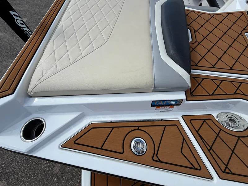 Slide: The Image of The image shows the stern of a 2019 Tigé 20RZX with padded seating and wood pattern. - 11