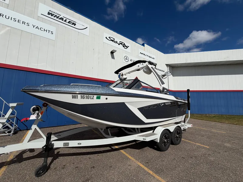 Slide: The Image of A 2019 Tigé 20RZX boat on a trailer in front of a building. - 1