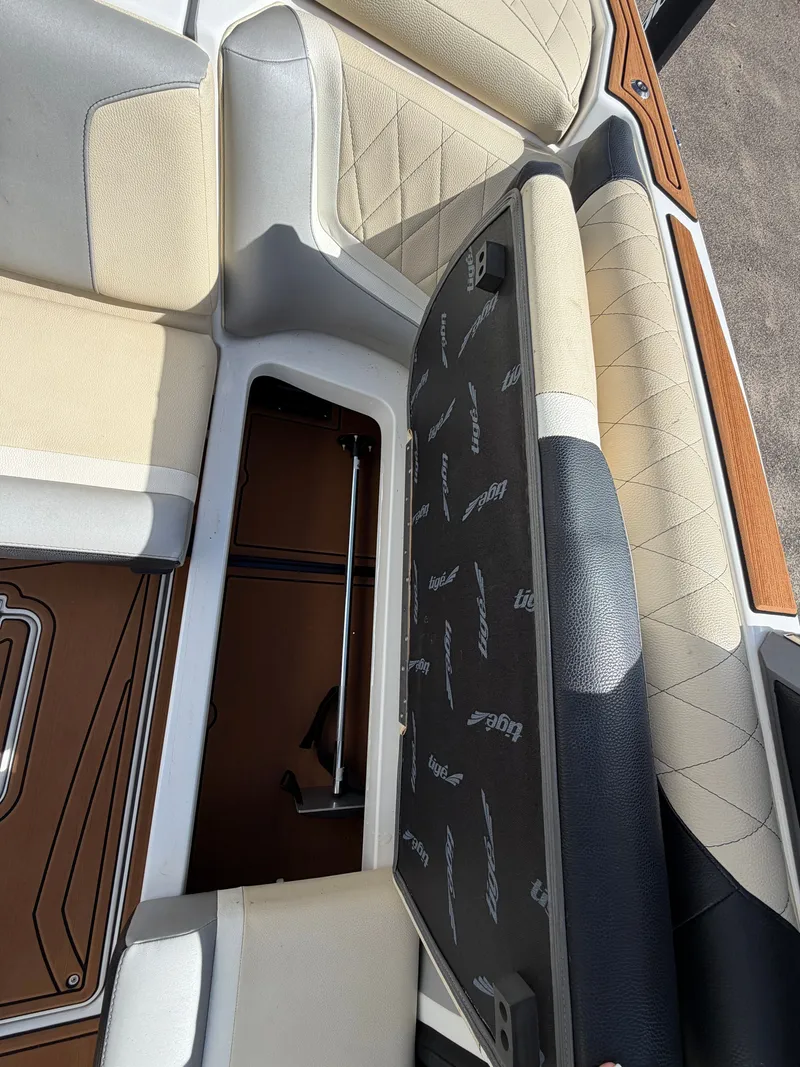 Slide: The Image of The image shows the interior of a 2019 Tigé 20RZX with a seat cushion lifted, revealing storage underneath. - 28