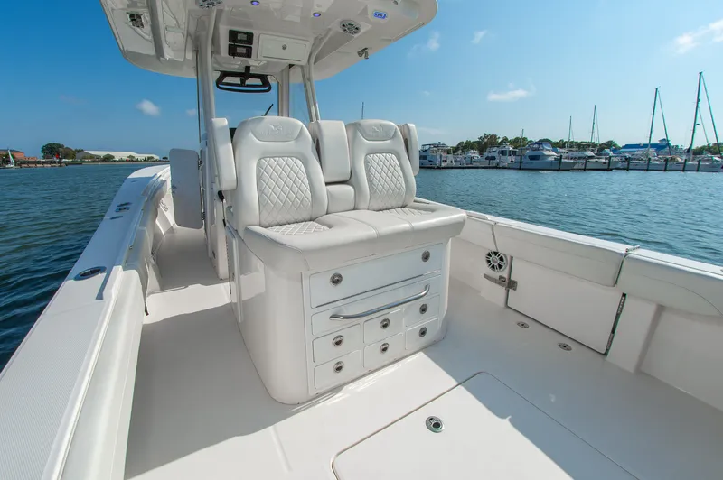 Slide: The Image of 2024 Regulator 31 with luxurious white seating and spacious deck, docked at a marina. - 5