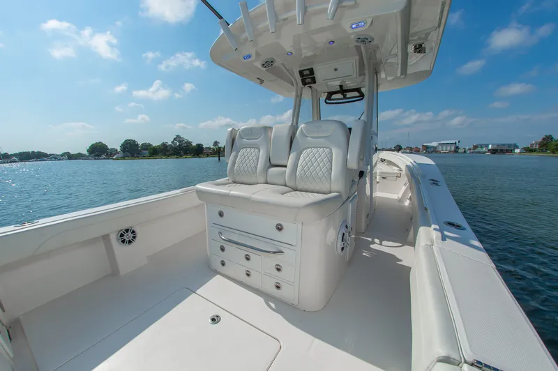 Slide: The Image of The image shows a modern boat with white upholstery and a spacious deck on calm waters. - 6