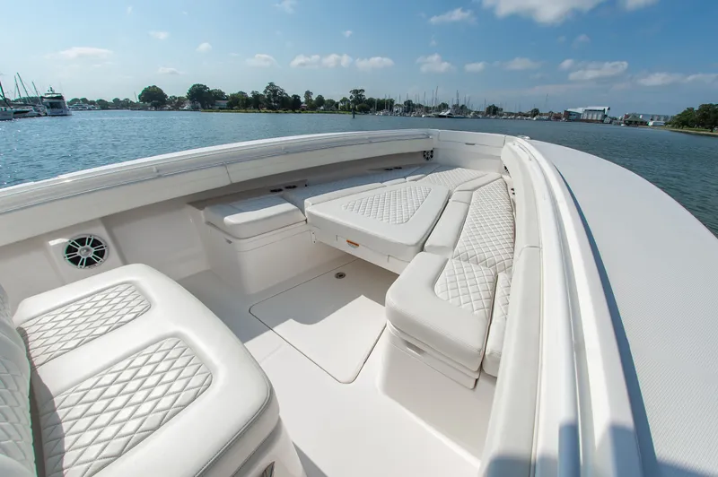 Slide: The Image of The image shows the bow of a 2024 Regulator 31 boat with white cushioned seating. - 17