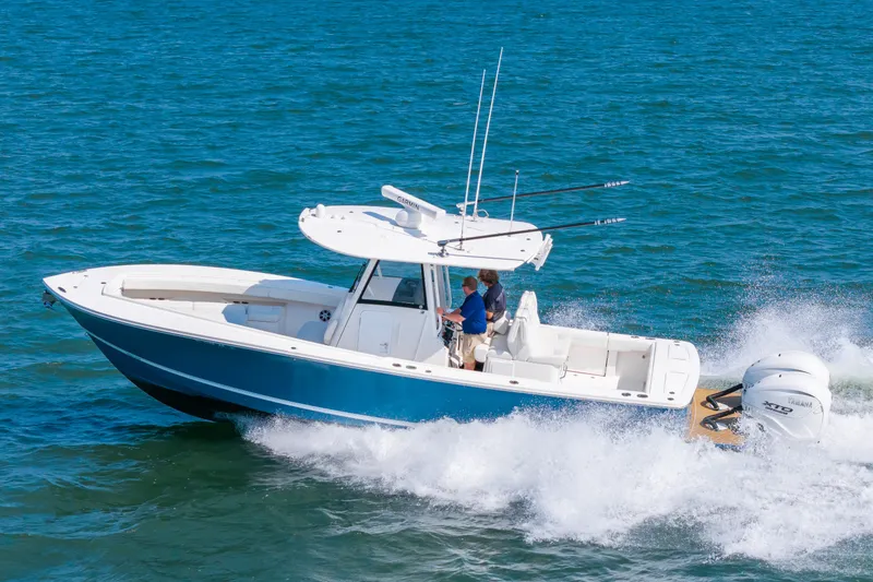Slide: The Image of A blue and white 2024 Regulator 31 speeds across the sea, with two people on board. - 22