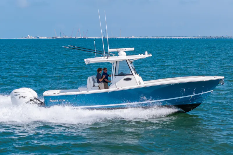 Slide: The Image of 2024 Regulator 31 on the water with two people aboard, equipped with twin outboard engines. - 25