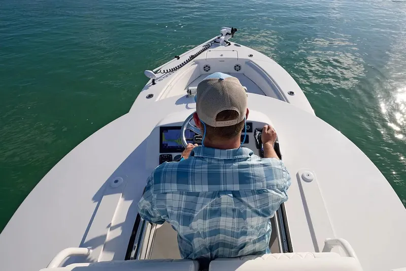 Slide: The Image of Manufacturer Provided Image: Person steering 2026 Regulator 30XO boat on calm water. - 9