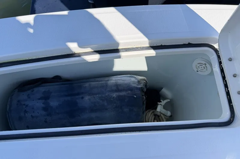 Slide: The Image of Open storage compartment on 2015 Regulator 25 boat with rope and cushion inside. - 21
