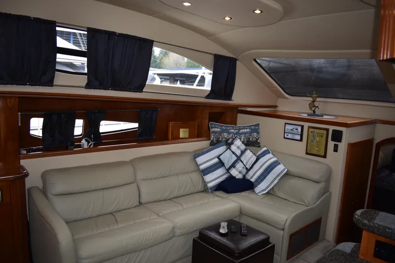Slide: The Image of Innenraum der Cruisers Yachts 415 Express Motoryacht von 2006 mit beigem Ledersofa und Fenstern. - 6