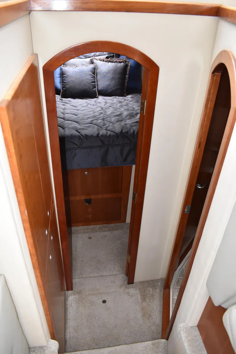 Slide: The Image of Ein schmaler Flur führt zu einem gemütlichen Schlafzimmer mit einem großen Bett und Holztüren. - 17