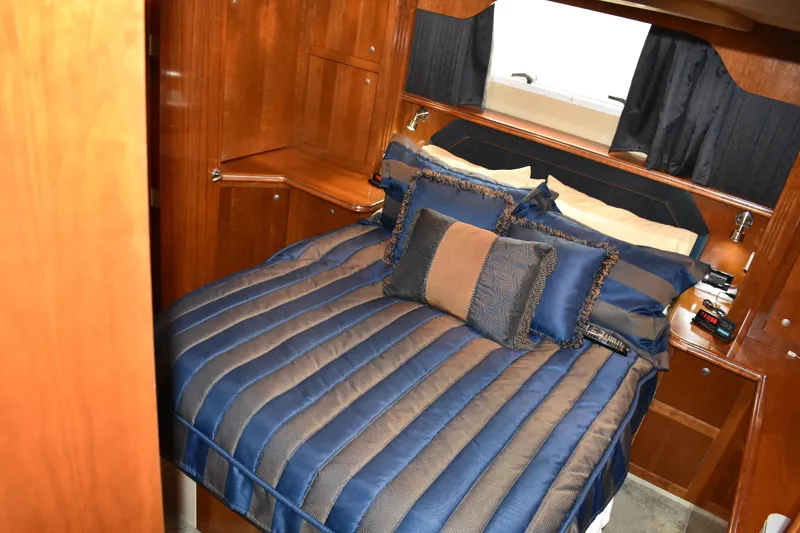 Slide: The Image of Kabine mit einem gemütlichen Bett, gestreifter blauer Bettwäsche und Holzmöbeln. - 12