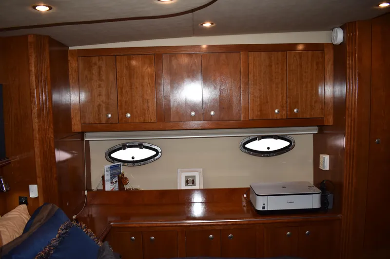 Slide: The Image of Die Kabine der Cruisers Yachts 415 Express Motoryacht von 2006 zeigt Holzmöbel und Bullaugen. - 14