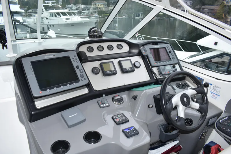 Slide: The Image of Das Cockpit der 2006 Cruisers Yachts 415 Express Motoryacht zeigt moderne Navigationsgeräte und ein elegantes Lenkrad. - 4