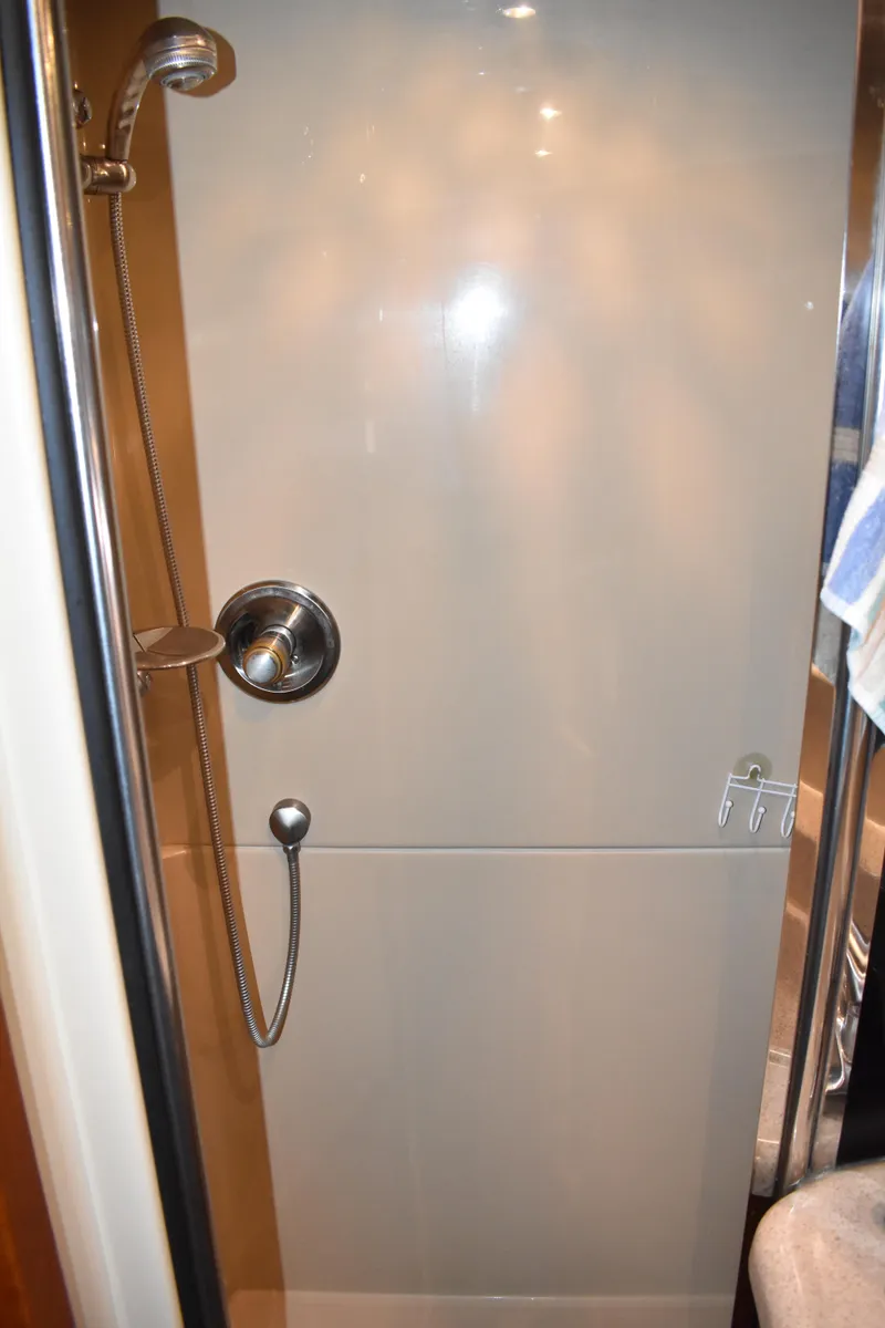Slide: The Image of Die Dusche in der Motoryacht hat eine verchromte Handbrause und eine glatte, helle Wandverkleidung. - 16