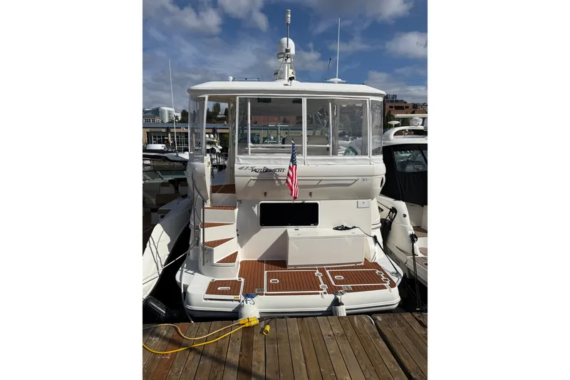 Slide: The Image of 2006 Cruisers Yachts 415 Express Motoryacht docked, rear view with American flag. - 1