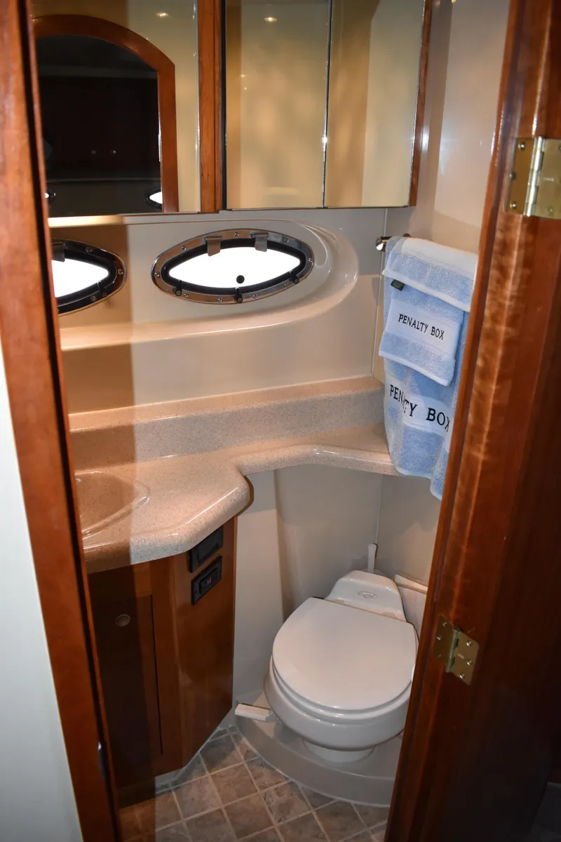 Slide: The Image of Das Bild zeigt ein elegantes Badezimmer in einer Yacht mit einem runden Fenster und modernen Armaturen. - 15