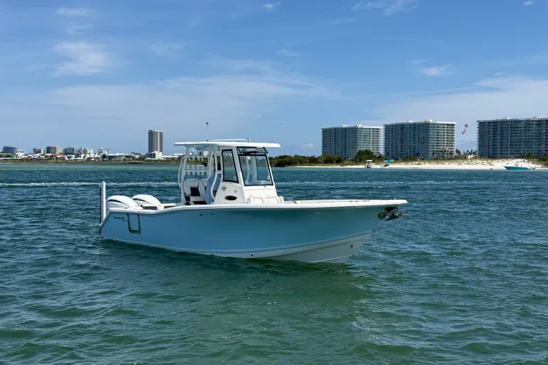 The Image of 2023 Tidewater 292 CC Adventure boat on water with city skyline background. - 4