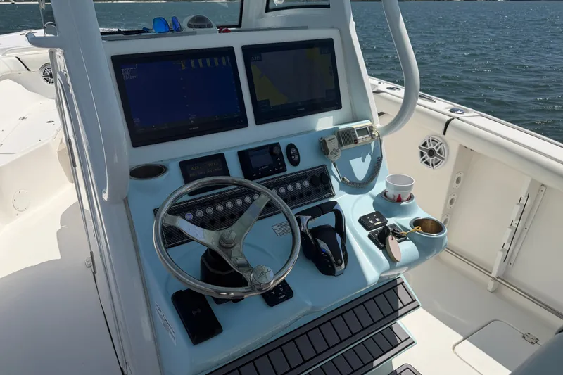 Slide: The Image of 2023 Tidewater 292 CC Adventure boat helm with dual screens and steering wheel. - 8