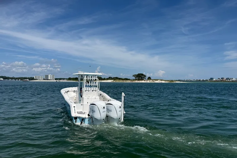Slide: The Image of 2023 Tidewater 292 CC Adventure boat cruising on open water under a clear blue sky. - 36