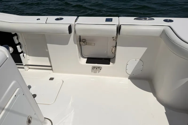 Slide: The Image of 2023 Tidewater 292 CC Adventure boat interior with sleek white seating and storage compartments. - 22