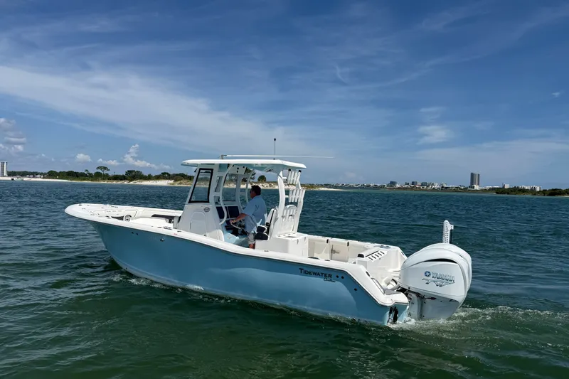 Slide: The Image of 2023 Tidewater 292 CC Adventure boat cruising on open water under a clear blue sky. - 35