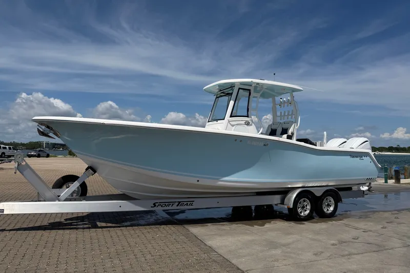 Slide: The Image of 2023 Tidewater 292 CC Adventure boat on trailer under clear blue sky. - 0