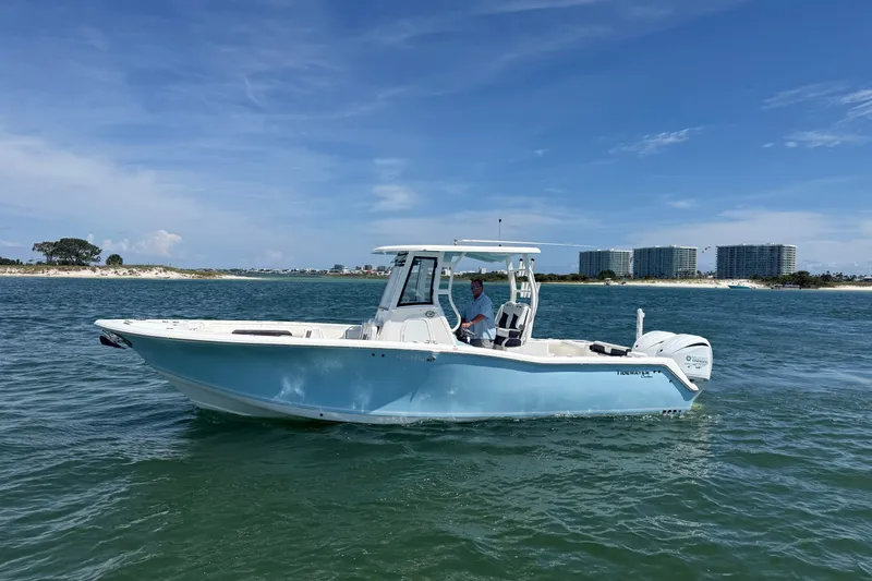 Slide: The Image of 2023 Tidewater 292 CC Adventure boat cruising on a sunny day near the coastline. - 34