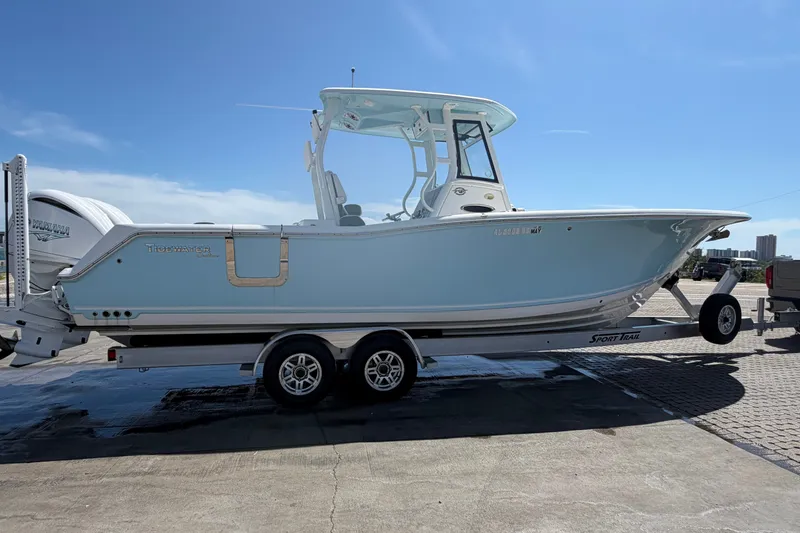 Slide: The Image of 2023 Tidewater 292 CC Adventure boat on trailer, side view, clear sky background. - 3