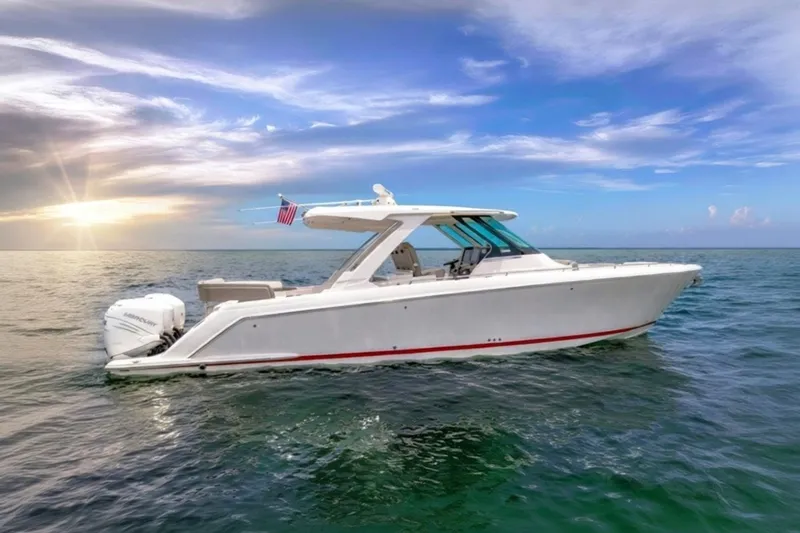 The Image of 2022 Tiara Yachts 38 LS cruising on open water at sunset. - 0