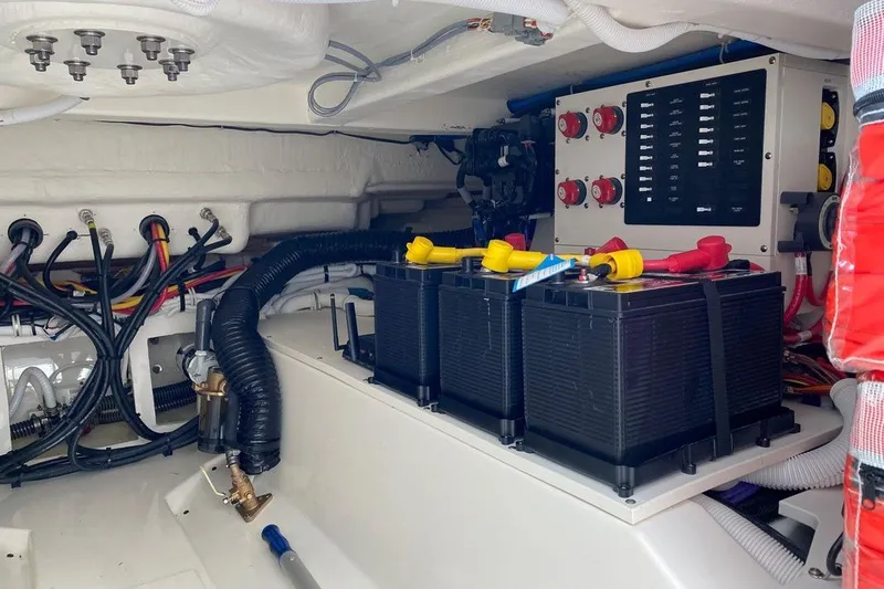 Slide: The Image of Engine compartment of 2022 Tiara Yachts 38 LS, featuring batteries and electrical panel. - 13