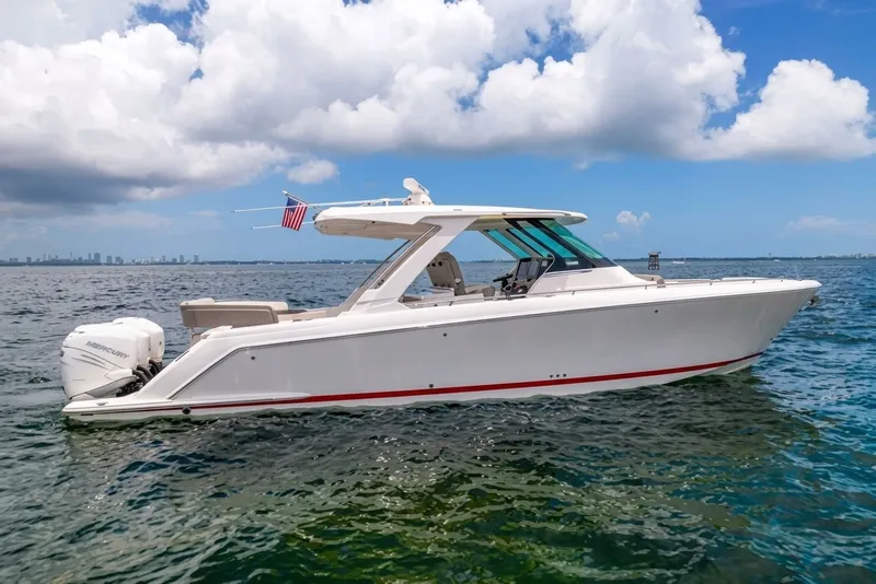 The Image of 2022 Tiara Yachts 38 LS cruising on open water under a partly cloudy sky. - 0