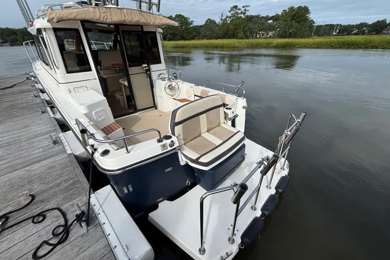 Slide: The Image of 2016 Cutwater C-28 boat docked, featuring spacious deck, seating area swim platform, reversible aft seat and cockpit shade cover (not deployed) - 10