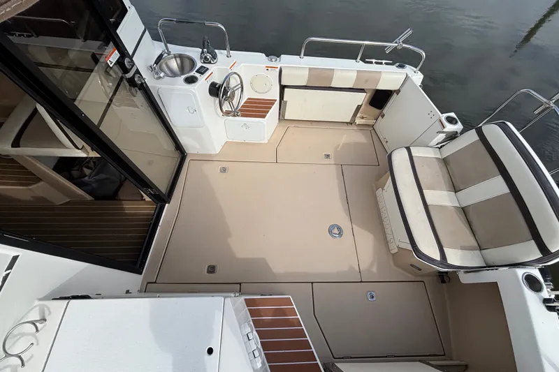 Slide: The Image of 2016 Cutwater C-28 cockpit interior with beige seating and wooden accents at dockside - 13