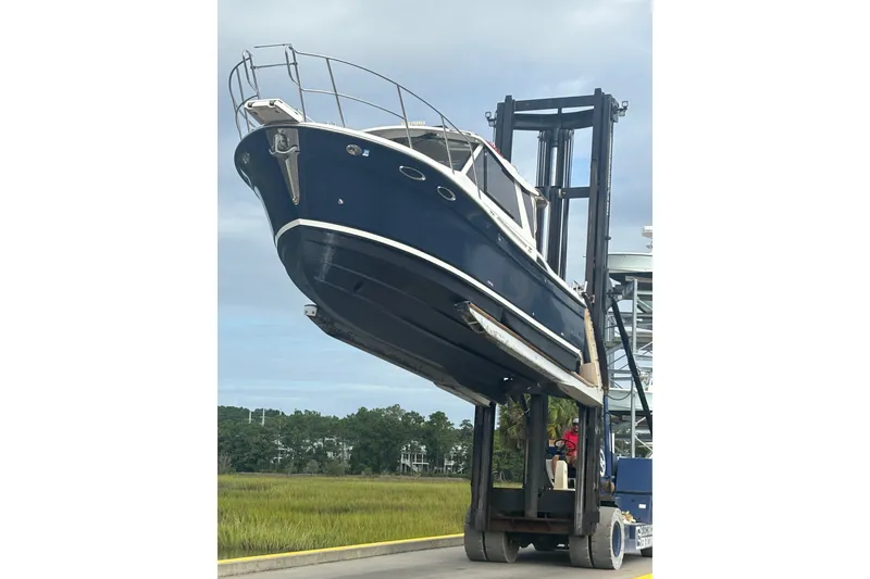 Slide: The Image of 2016 Cutwater C-28 boat lifted by forklift, blue hull, outdoor setting. - 8