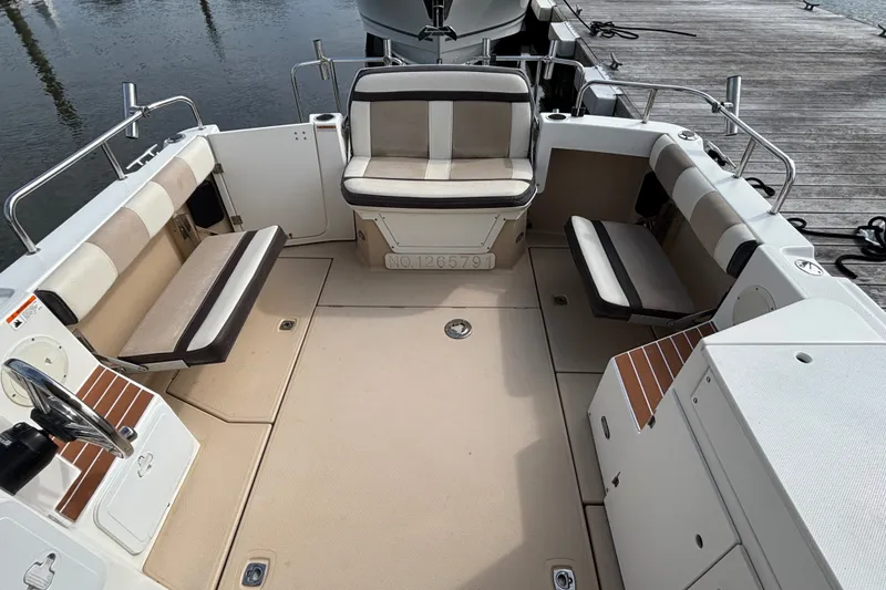 Slide: The Image of 2016 Cutwater C-28 cockpit interior with beige seating and wooden accents at dockside - 12